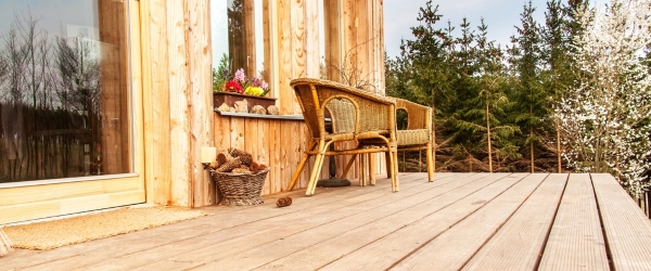 Wooden floor, Wooden terrace at an ecological house. Wicker chairs on a wooden terrace by the forest.